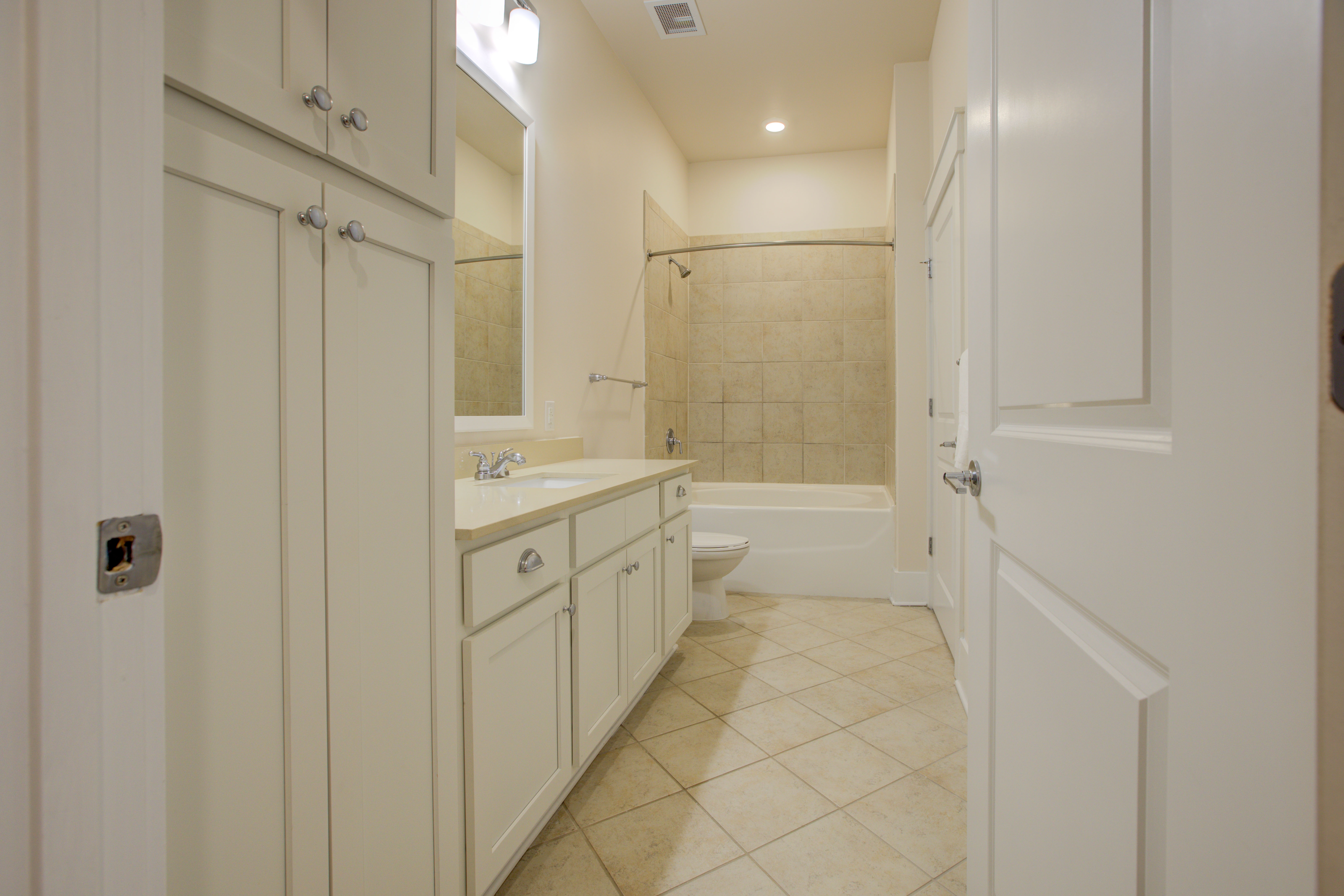Studio bathroom with sink, bathtub, shower, and cabinets at Holly Crest Apartments